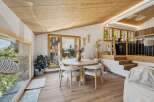 Experience modern mountain living in this stunning dining area, featuring a sleek round table with plush chairs perfect for intimate gatherings.