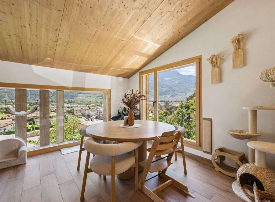 Experience breathtaking mountain views from this charming dining area, featuring a rustic wooden table perfect for family gatherings.