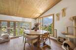 Experience breathtaking mountain views from this charming dining area, featuring a rustic wooden table perfect for family gatherings.
