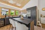 Experience modern living in this stunning kitchen featuring a sleek dark countertop island with comfortable bar seating.