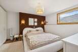 Experience serene mountain living in this charming bedroom, featuring a cozy bed with plush bedding and a unique heart-shaped headboard.