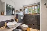 Experience modern comfort in this beautifully appointed bathroom, featuring a sleek vessel sink atop a stylish vanity.