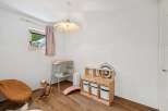 This charming nursery features a comfortable changing station, a playful rocking horse, and a wooden toy storage unit with ample space for organizing children's items.