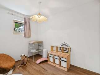 This charming nursery features a comfortable changing station, a playful rocking horse, and a wooden toy storage unit with ample space for organizing children's items.