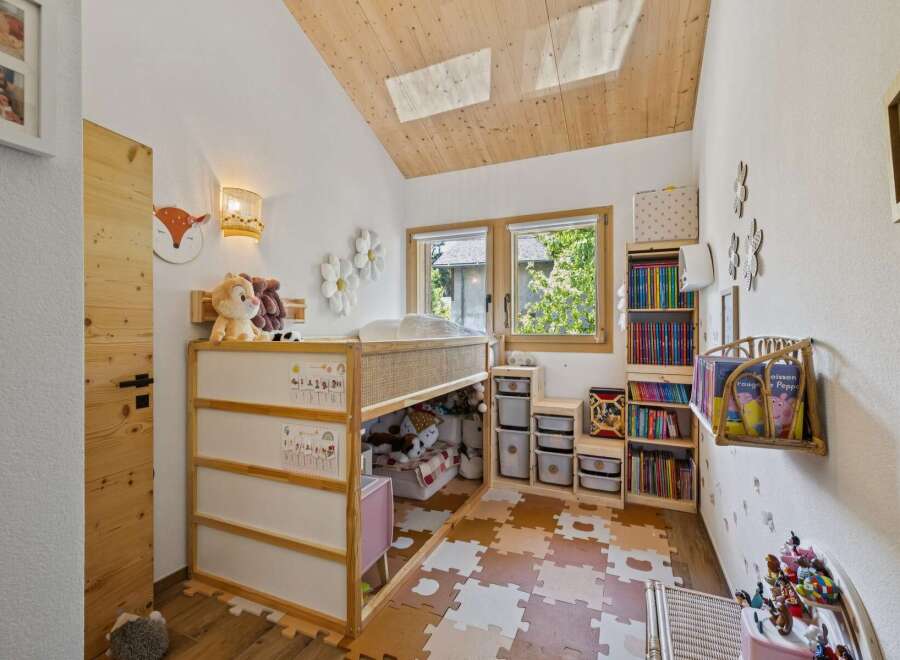 This charming children's room features a loft bed with ample storage underneath, perfect for toys and books.
