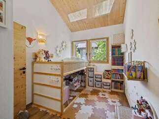 This charming children's room features a loft bed with ample storage underneath, perfect for toys and books.