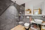 Experience modern luxury in this stunning bathroom featuring a spacious walk-in shower with elegant grey marble tiles and a sleek glass enclosure.