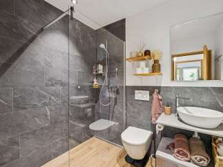 Experience modern luxury in this stunning bathroom featuring a spacious walk-in shower with elegant grey marble tiles and a sleek glass enclosure.