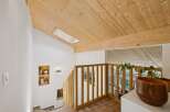 Ascend to the upper level of this charming home, where a wooden staircase leads to a bright and airy space.