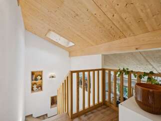 Ascend to the upper level of this charming home, where a wooden staircase leads to a bright and airy space.