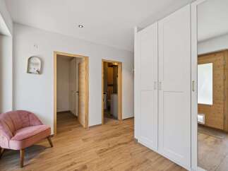 Step into this inviting entryway featuring a plush pink accent chair perfect for a moment of relaxation.