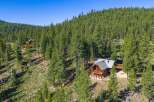 Nestled amidst a dense forest of towering pine trees, this charming log cabin offers a serene mountain retreat.