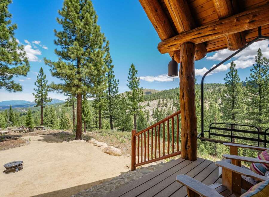 Experience breathtaking mountain views from the covered porch of this rustic log cabin.