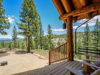 Experience breathtaking mountain views from the covered porch of this rustic log cabin.