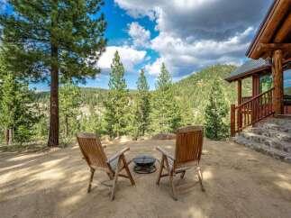 Experience the ultimate mountain retreat with this stunning log cabin, offering breathtaking views of a lush, forested landscape.