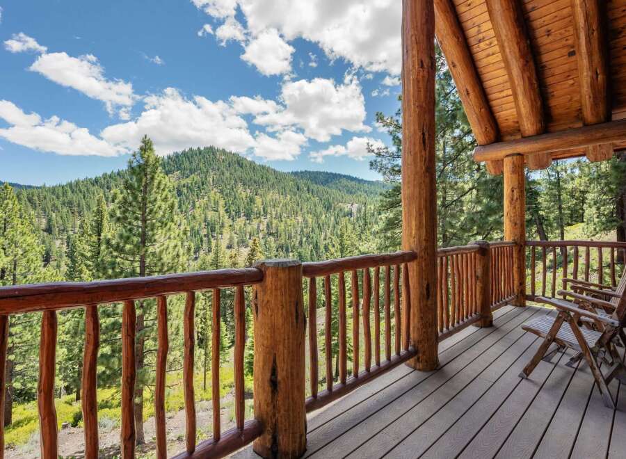 Experience breathtaking mountain views from the expansive wooden deck of this stunning log cabin.