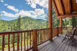 Experience breathtaking mountain views from the expansive wooden deck of this stunning log cabin.