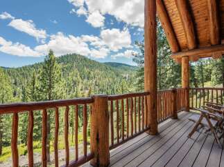 Experience breathtaking mountain views from the expansive wooden deck of this stunning log cabin.