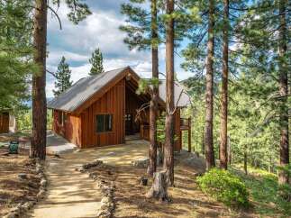 Nestled amidst towering pine trees, this charming wooden cabin offers a serene mountain retreat.