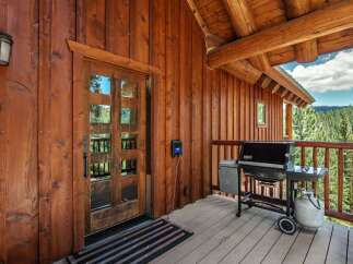 Experience the ultimate mountain retreat with this charming log cabin featuring a spacious wooden deck perfect for outdoor entertaining.