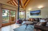 Experience rustic charm in this cozy living room featuring a striking red wood-burning stove and expansive sliding glass doors that open to breathtaking mountain views.