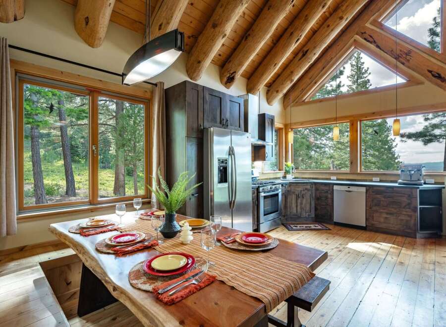 Experience rustic charm and modern comfort in this stunning log cabin kitchen and dining area.