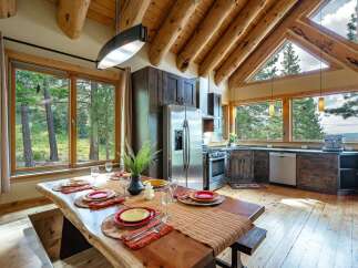 Experience rustic charm and modern comfort in this stunning log cabin kitchen and dining area.