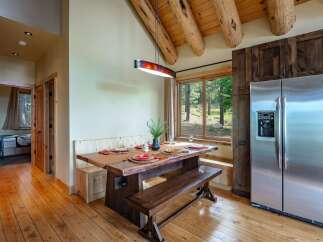 Experience rustic charm in this dining area featuring a live-edge wood table and benches, perfect for intimate gatherings.