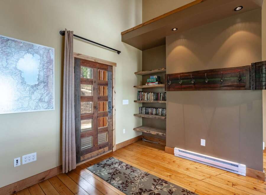 Step into this inviting entryway featuring a rustic wooden door with glass panels, perfect for letting in natural light.