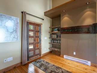 Step into this inviting entryway featuring a rustic wooden door with glass panels, perfect for letting in natural light.