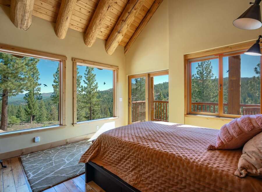 Experience breathtaking mountain views from this stunning bedroom, featuring expansive windows that bring the outdoors in.