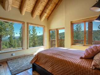 Experience breathtaking mountain views from this stunning bedroom, featuring expansive windows that bring the outdoors in.