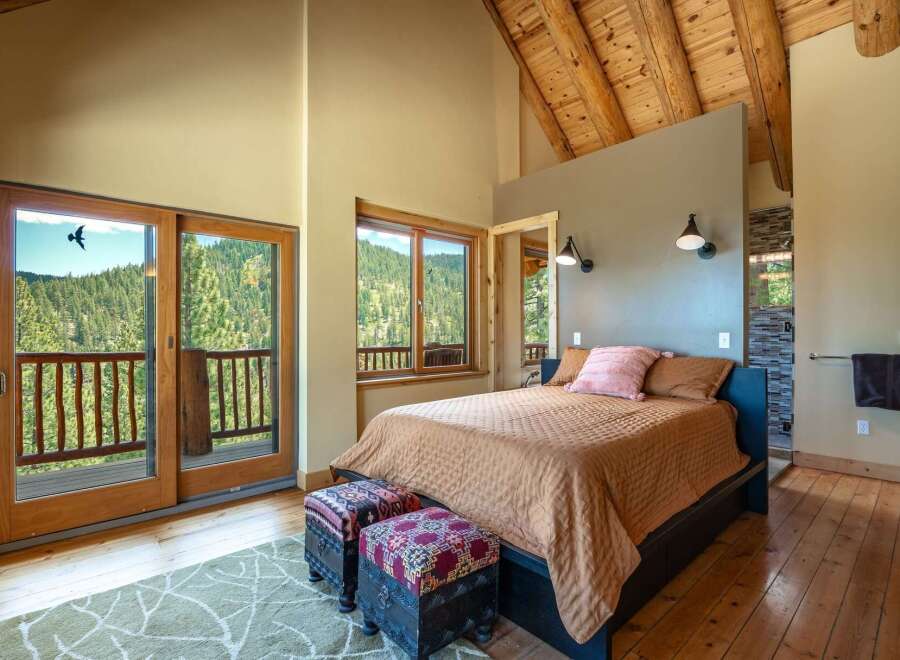 Experience breathtaking mountain views from this stunning bedroom, featuring a private balcony accessed through large sliding glass doors.