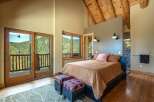 Experience breathtaking mountain views from this stunning bedroom, featuring a private balcony accessed through large sliding glass doors.