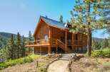 Experience rustic charm in this stunning log cabin nestled amidst a picturesque mountain landscape.