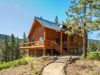 Experience rustic charm in this stunning log cabin nestled amidst a picturesque mountain landscape.