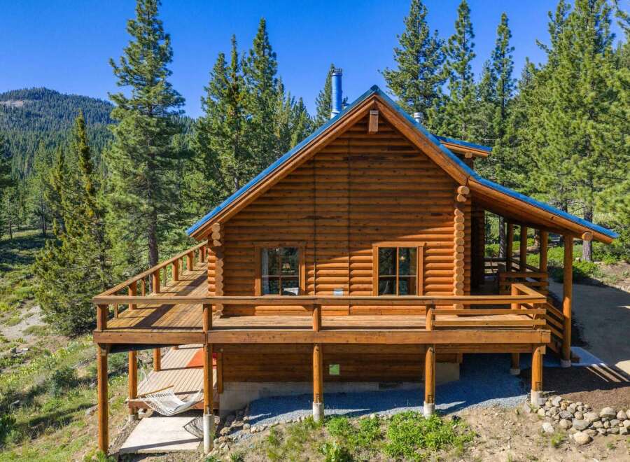 Experience rustic charm in this stunning log cabin nestled amidst towering pine trees.