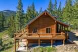 Experience rustic charm in this stunning log cabin nestled amidst towering pine trees.