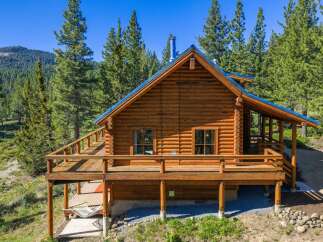Experience rustic charm in this stunning log cabin nestled amidst towering pine trees.