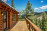 Experience breathtaking mountain views from the expansive wooden deck of this charming log cabin.