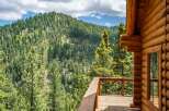 Experience breathtaking mountain views from the expansive wooden deck of this charming log cabin.