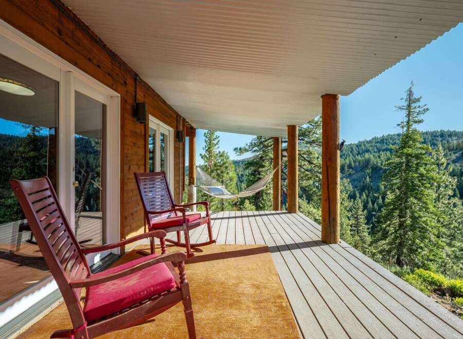 Enjoy breathtaking mountain views from this charming covered porch, complete with comfortable rocking chairs and a relaxing hammock.