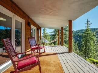Enjoy breathtaking mountain views from this charming covered porch, complete with comfortable rocking chairs and a relaxing hammock.