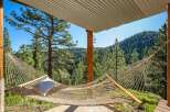 Relax and unwind in this serene mountain retreat, featuring a comfortable hammock perfect for enjoying the breathtaking forest views.