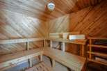 Experience ultimate relaxation in this beautifully crafted wooden sauna, featuring multiple tiered benches for comfortable seating.