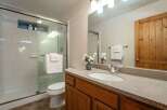 This bright and clean bathroom features a spacious glass-enclosed shower with white subway tile and a convenient toilet.