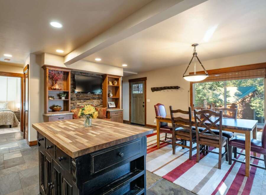 This open-concept living space features a rustic dining area with a large wooden table and comfortable seating, perfect for family gatherings.