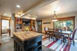 This open-concept living space features a rustic dining area with a large wooden table and comfortable seating, perfect for family gatherings.
