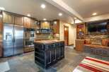 This spacious kitchen boasts a large stainless steel refrigerator, double ovens, and a charming wooden island perfect for meal prep and gathering.