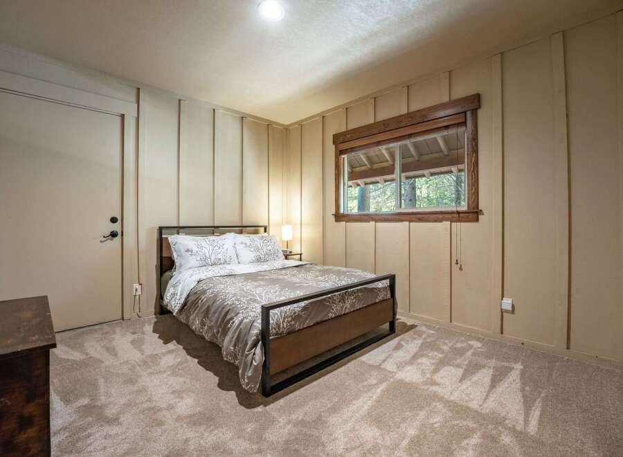 This cozy bedroom features a comfortable queen-size bed with a nature-inspired duvet cover, perfect for a restful night's sleep.